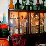 Chinese rosewood cabinets  showcasing Continental pottery and porcelain, capped by dramatic Japanese Awaji slather pots.